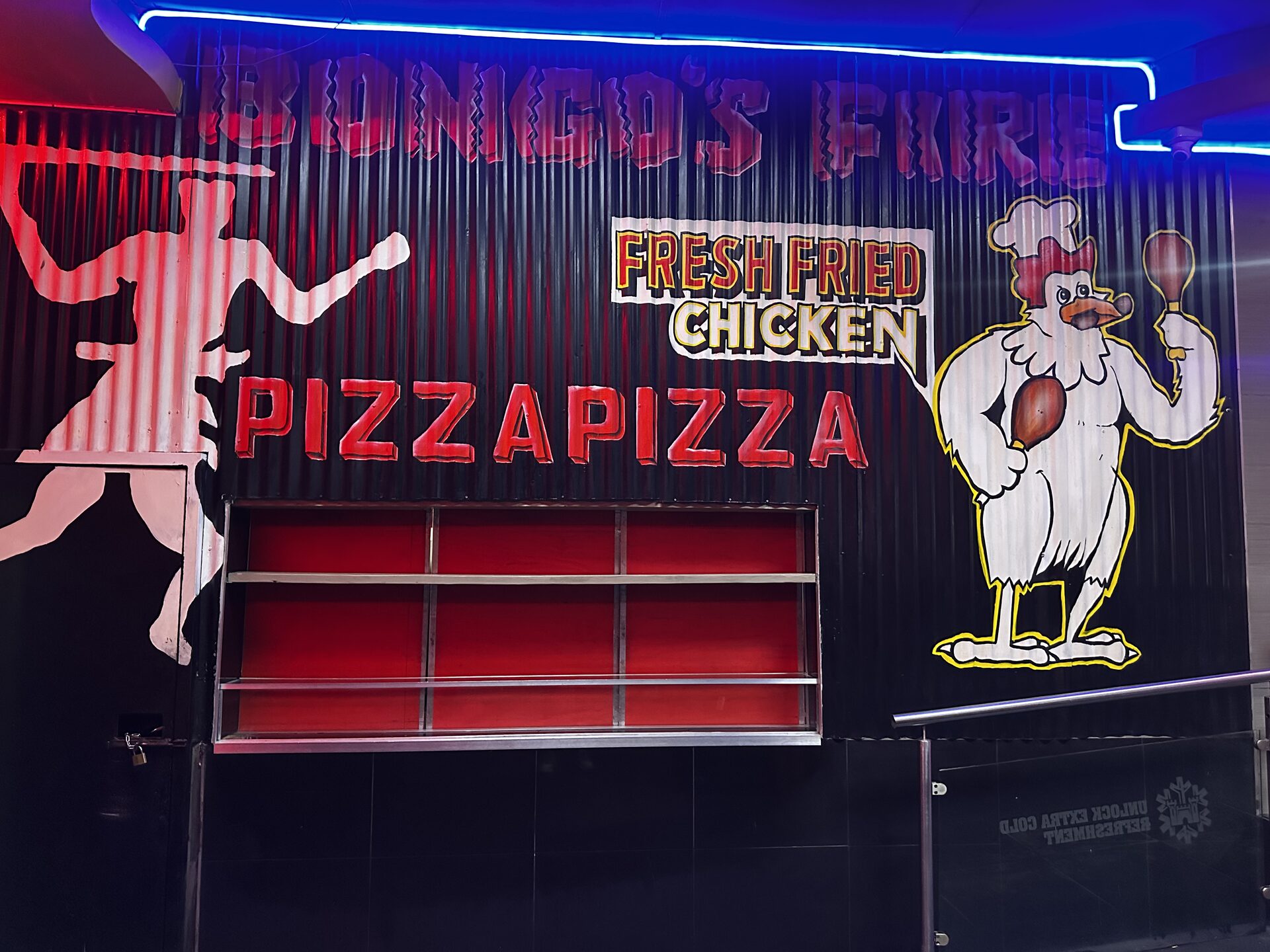 Bongo's Fire kitchen counter with fresh fried chicken and pizza signage at Cheeky Tiger Kempton Park
