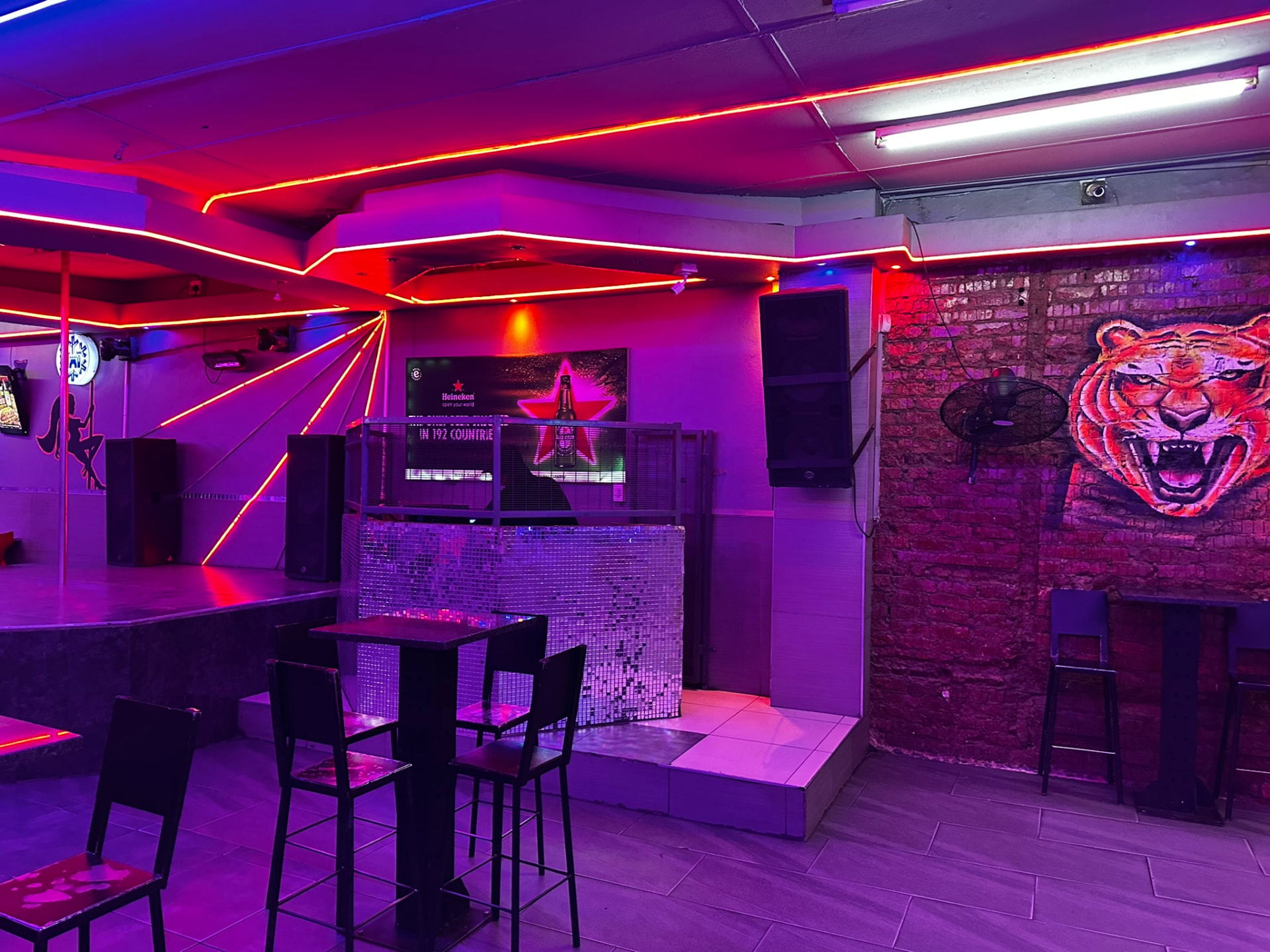 DJ booth and tiger mural on exposed brick at Cheeky Tiger Germiston