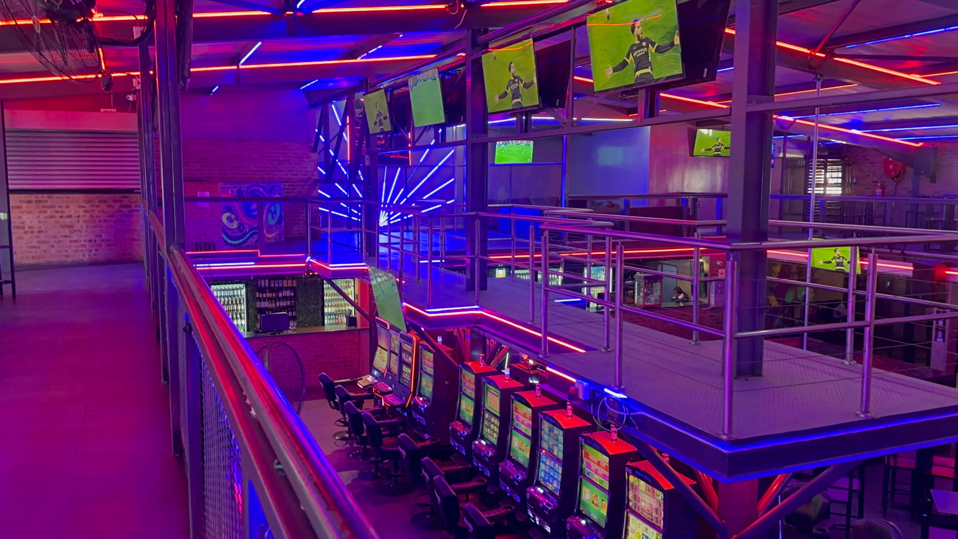 Row of slot machines below the sports screens at Cheeky Tiger Midrand