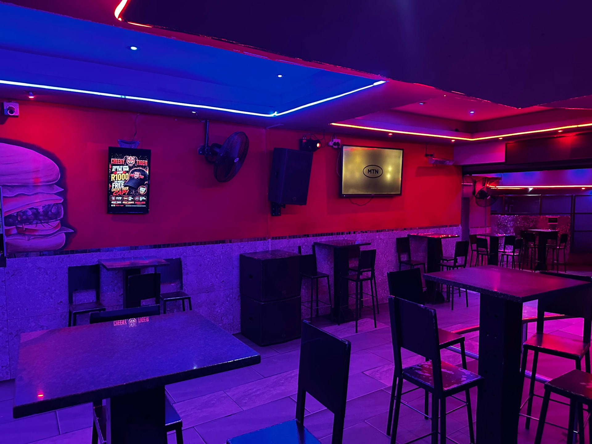 Seating area with neon lighting at Cheeky Tiger Germiston